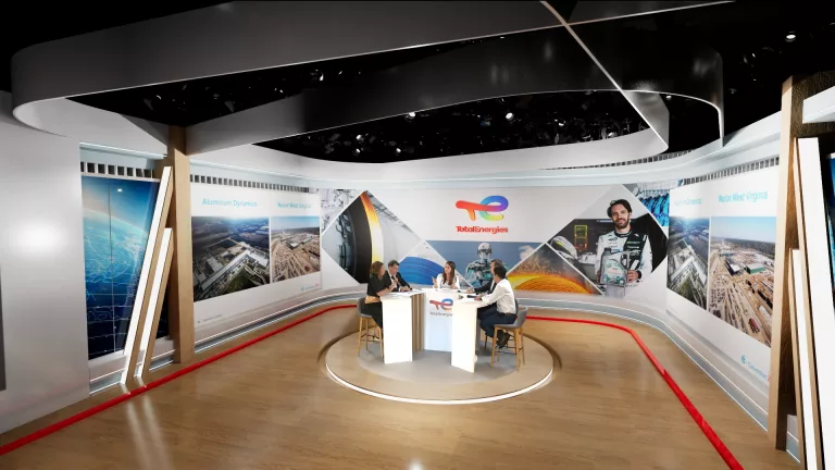 Studio moderne avec présentateurs et écrans.